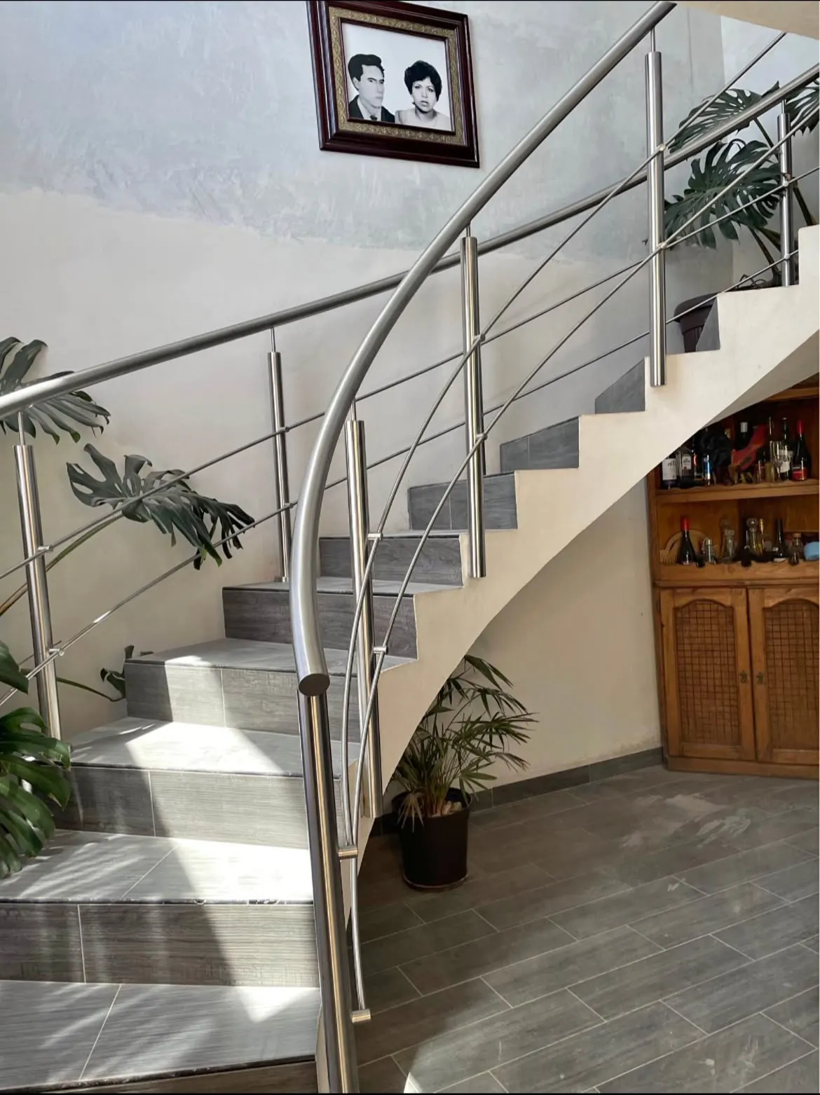Barandal curvo de acero inoxidable en escalera